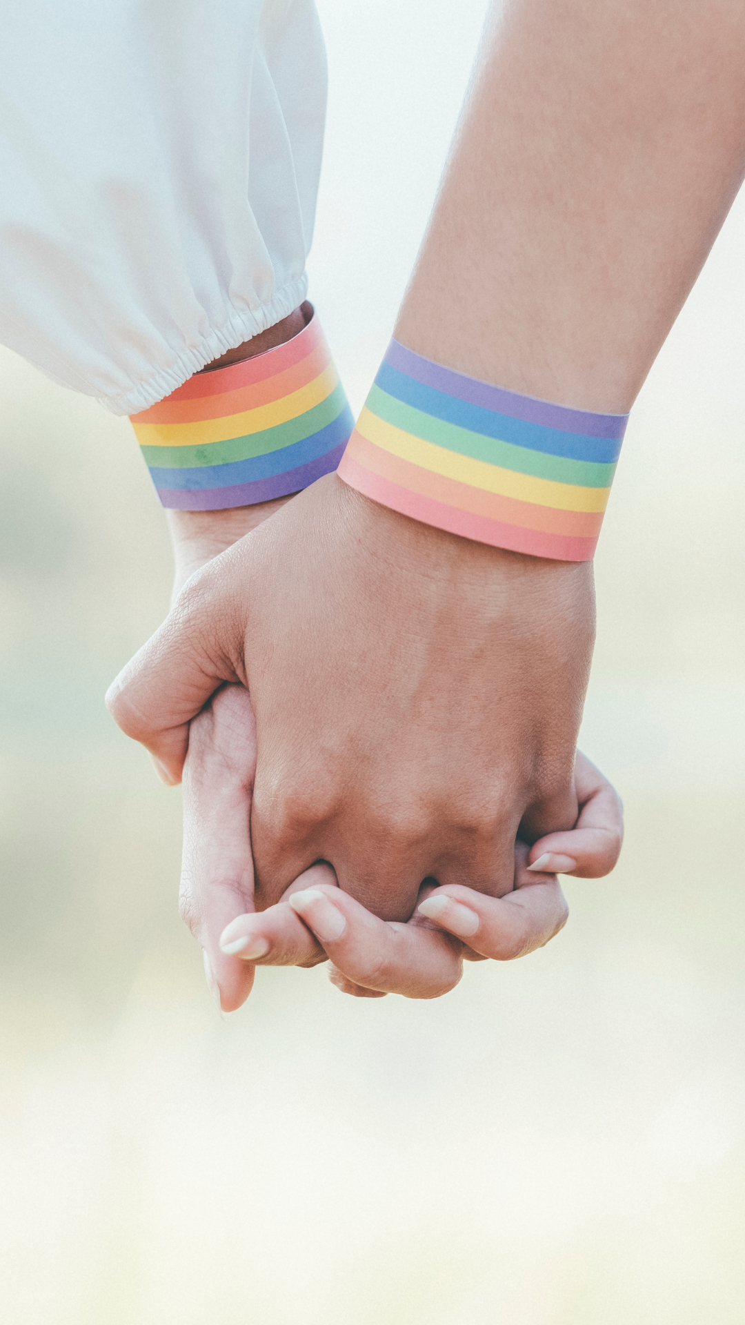 LGBTQ+ Couple Holding hands LGBTQ+ couple holding hands with pride wristbands